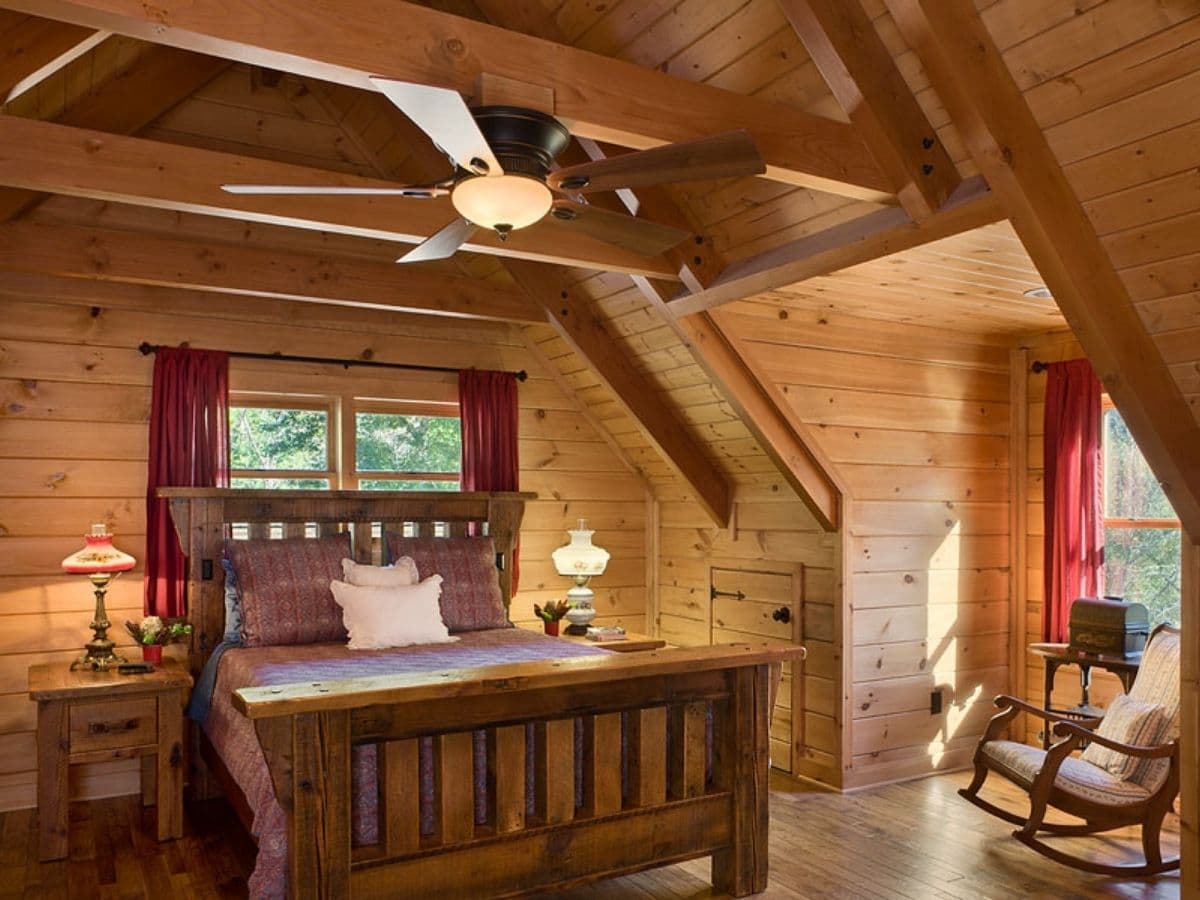 wood sleigh bed in loft bedroom of log cabin