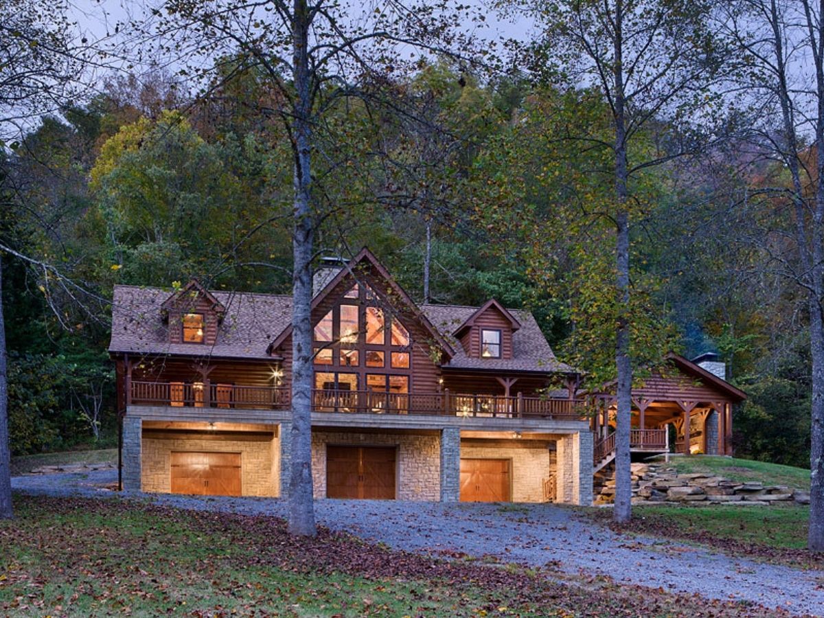 log cabin with garage doors below and lights on