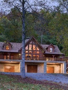 log cabin with garage doors below and lights on