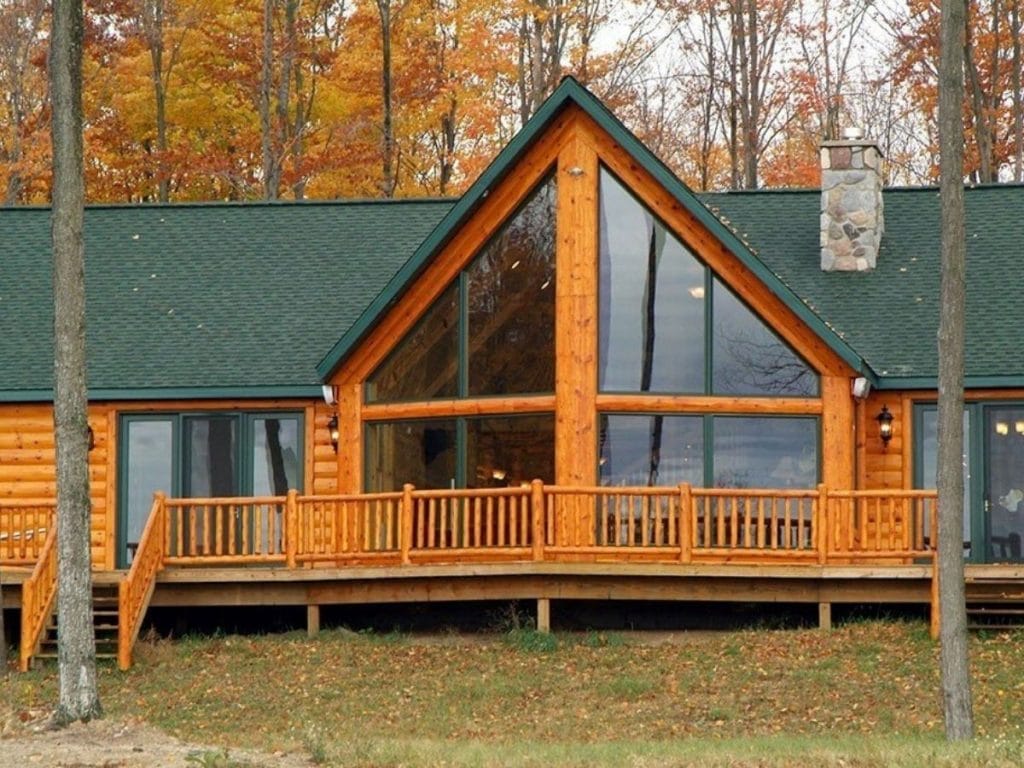 great room on front of log cabin with deck outside picture windows