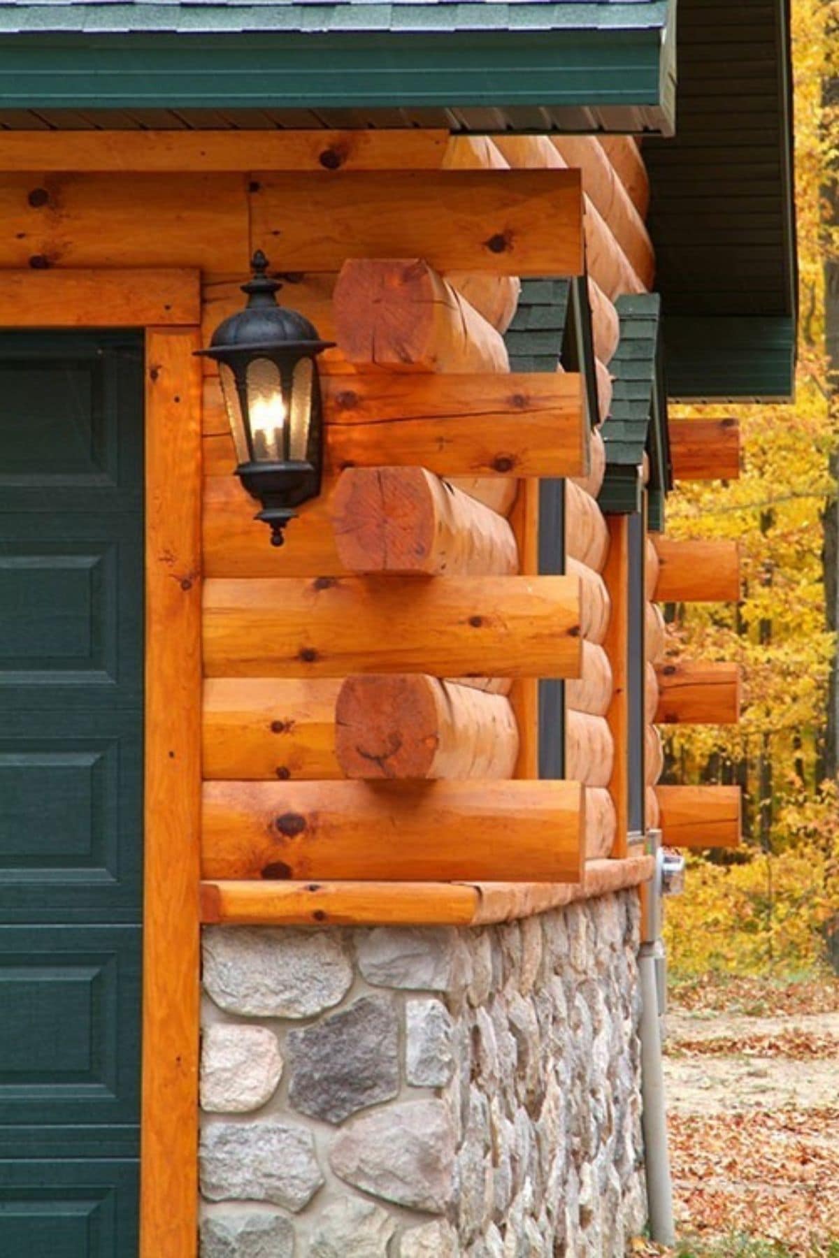 corner of log cabin with green door on left and stone below log on right