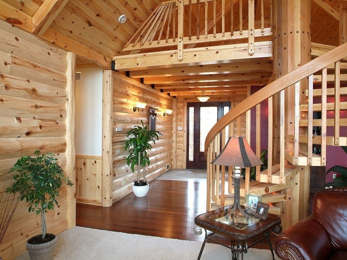 entry space in log cabin with knotty pine paneling and dark wood floors