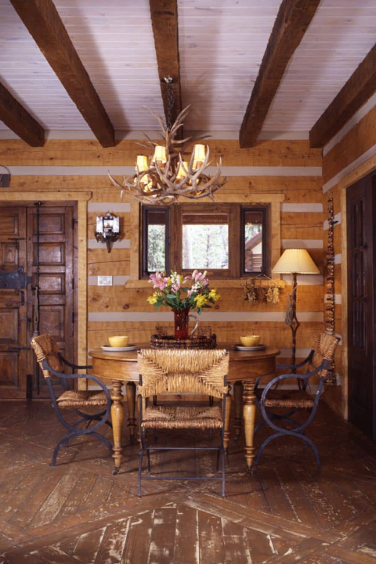 dining table in log cabin with log walls and chandelier