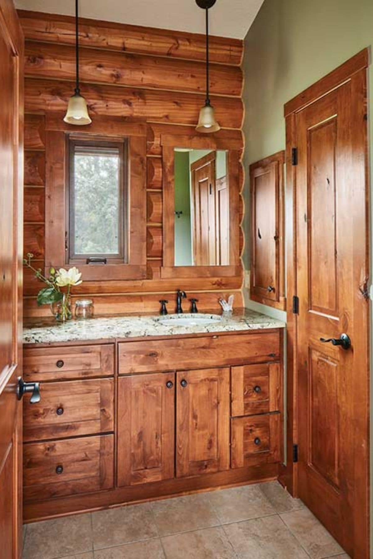 wood cabinets and doors under marble countertop in bathroom
