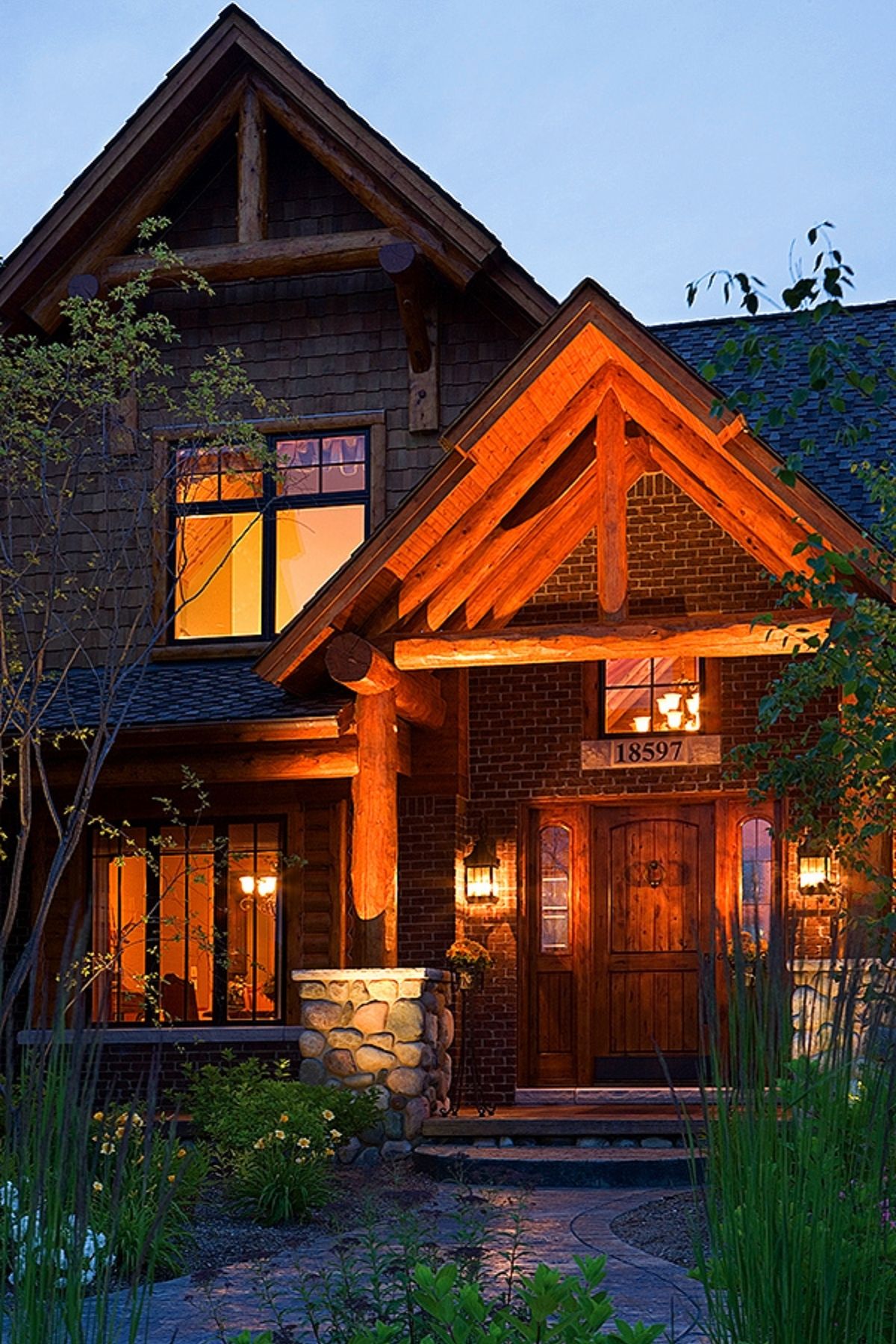 front entry of log cabin after dark with lights around front entry