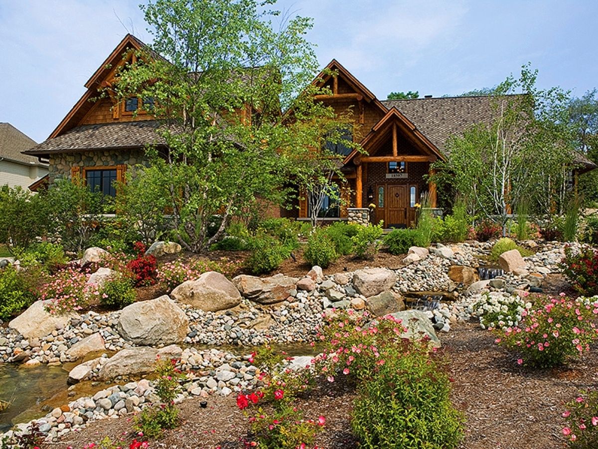 rock and shrubbery landscaping in front of log cabin