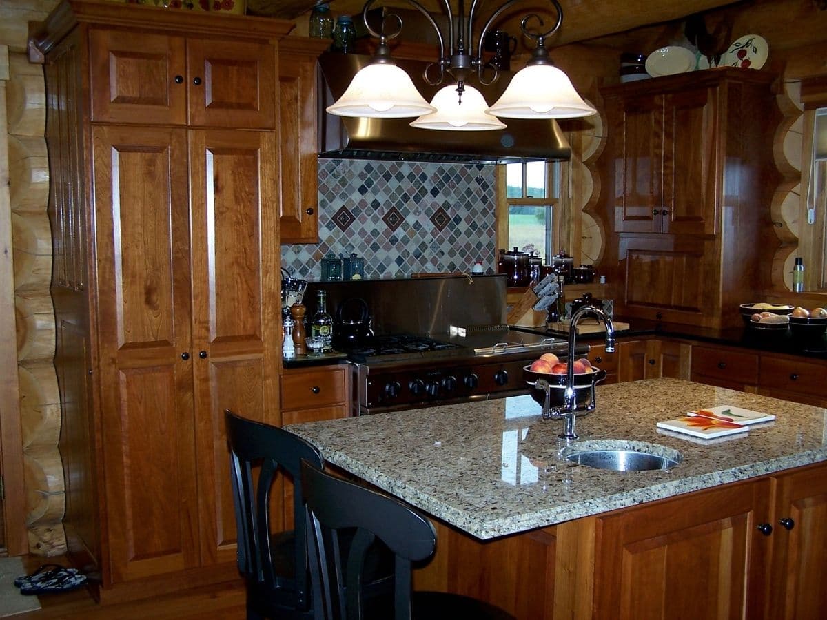 kitchen with island and granite countertops and stone tiled backsplash behind stove