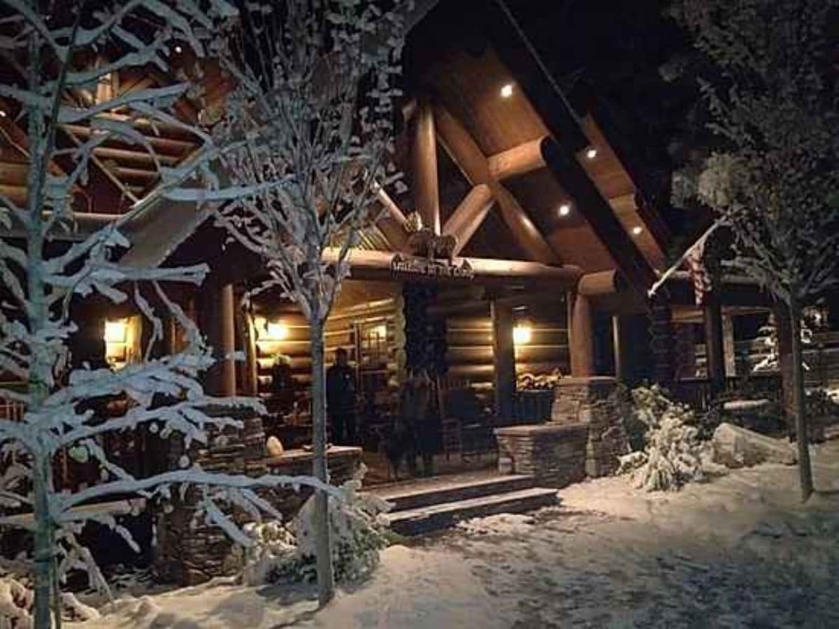 front of log cabin after dark with lights on porch