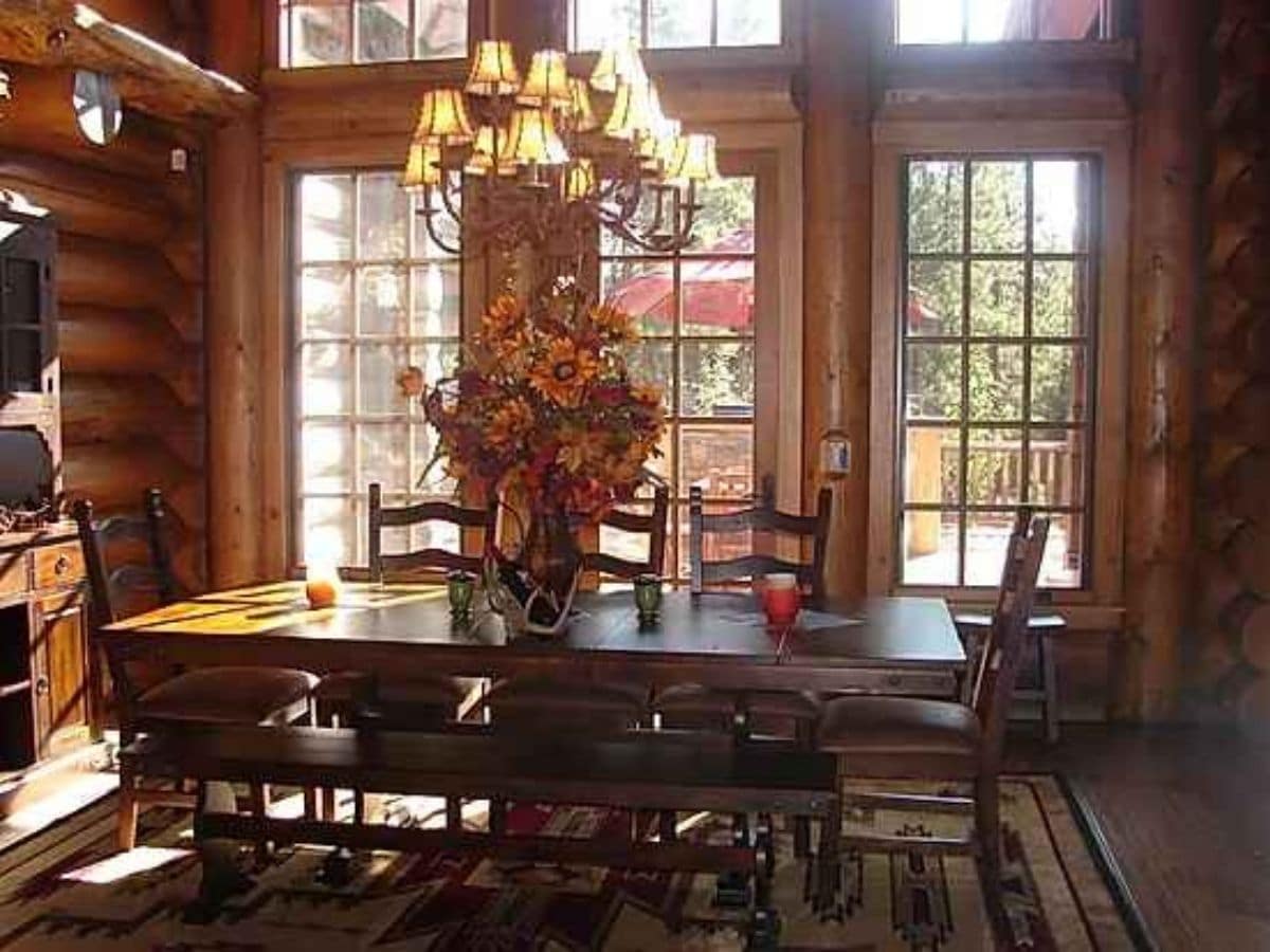 wood dining table in front of great wall of glass windows
