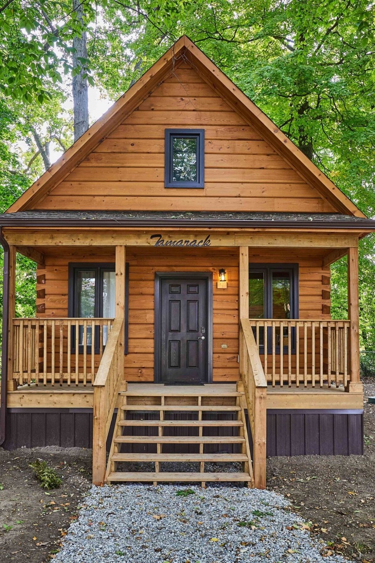 small log cabin with black door and small porch