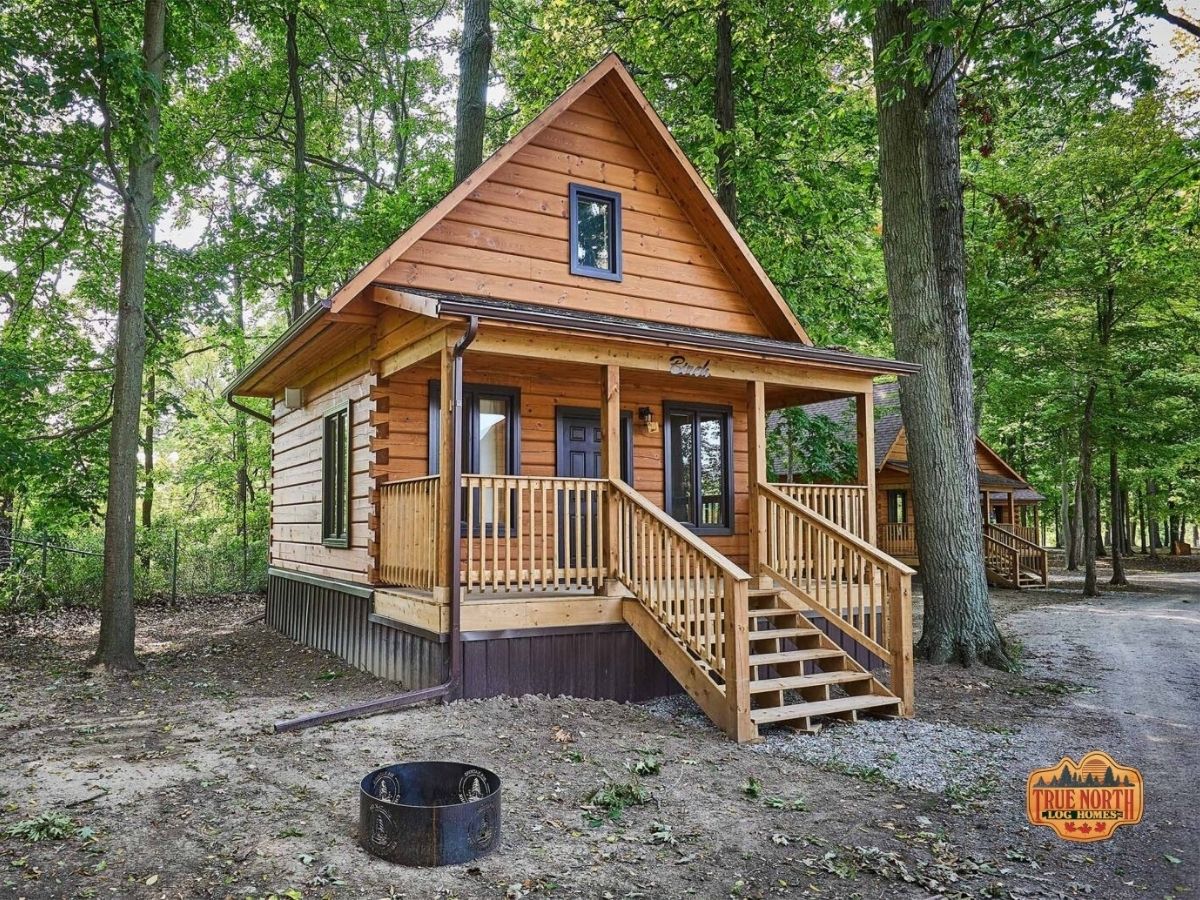 small log cabin against treeline with small porch