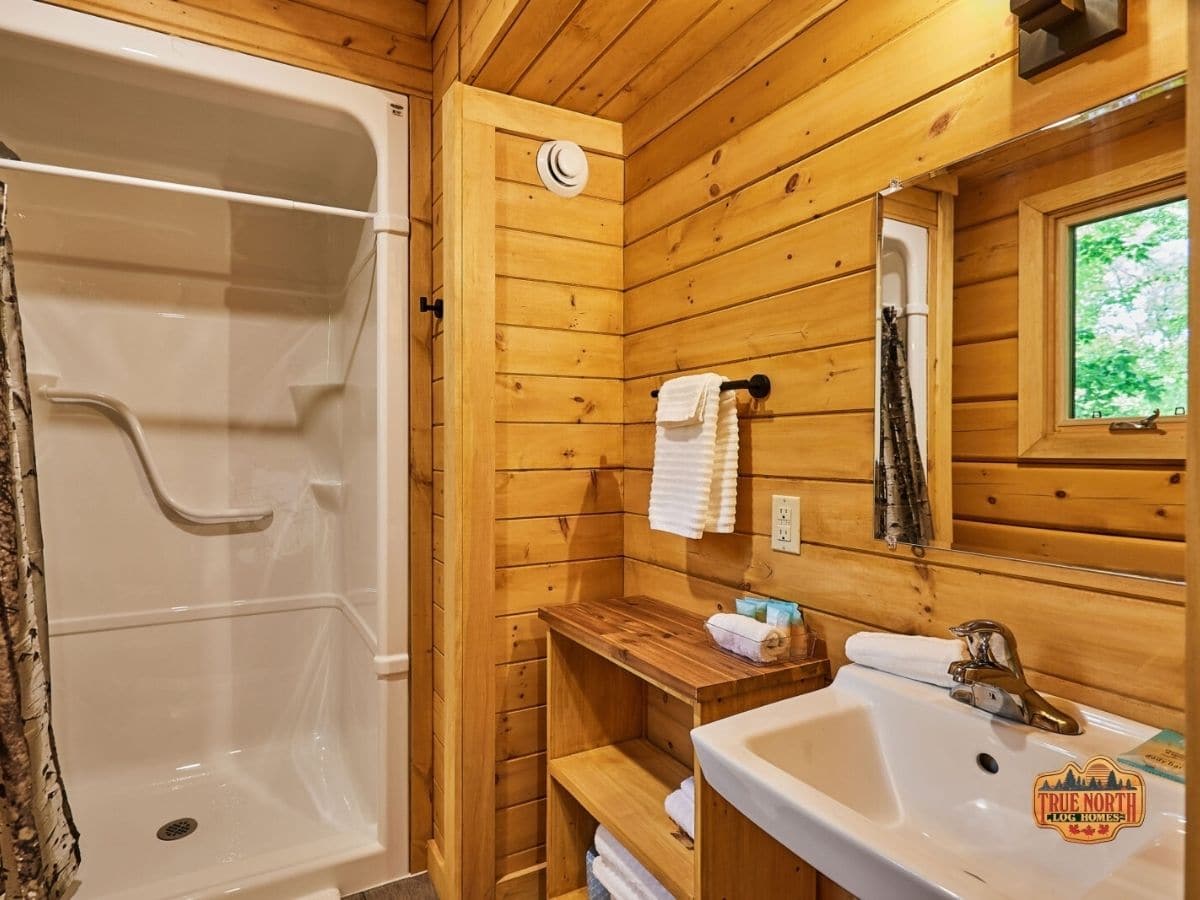 white shower stall in wood bathroom with white vanity