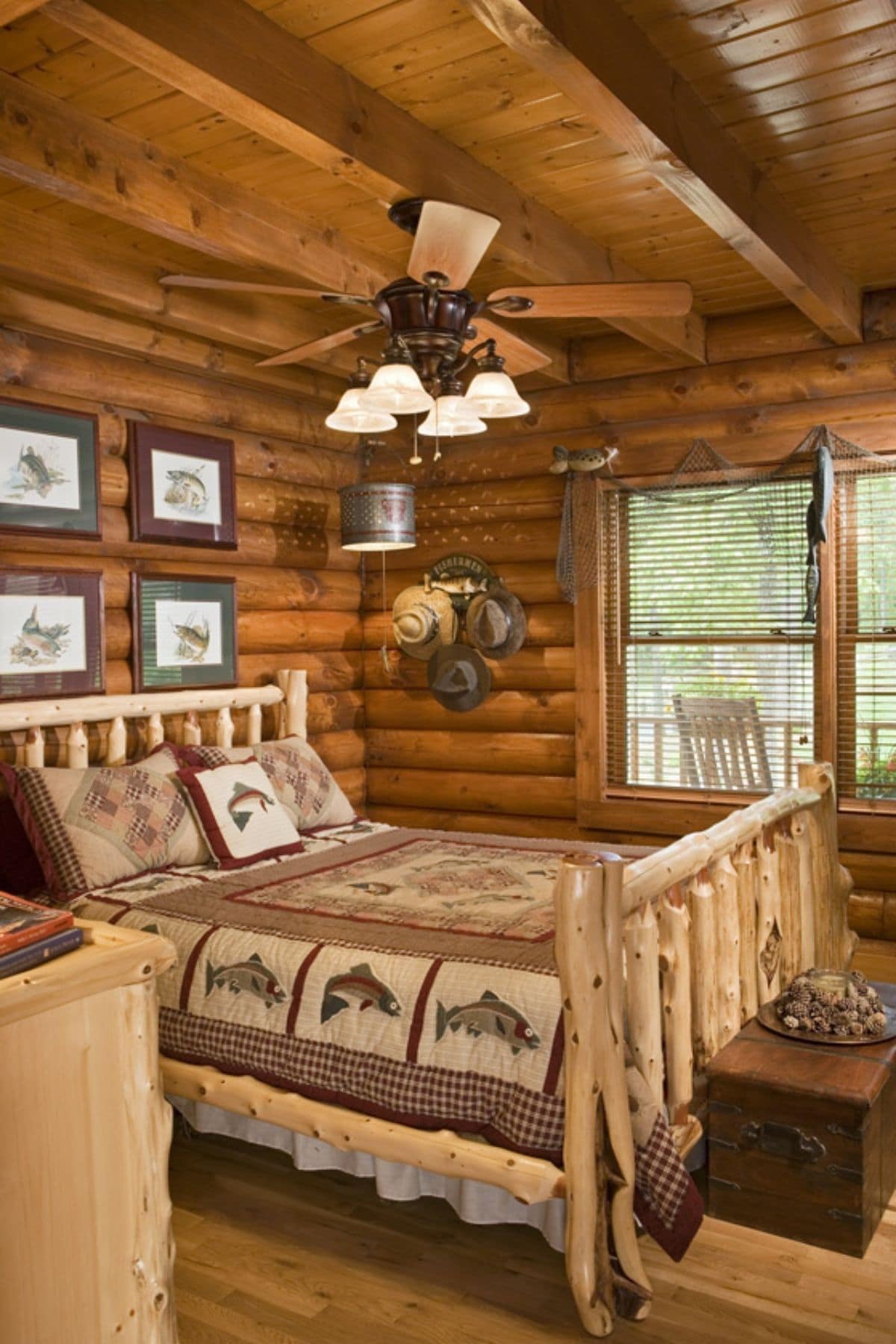 log bed frame in log bedroom with ceiling fan above the bed