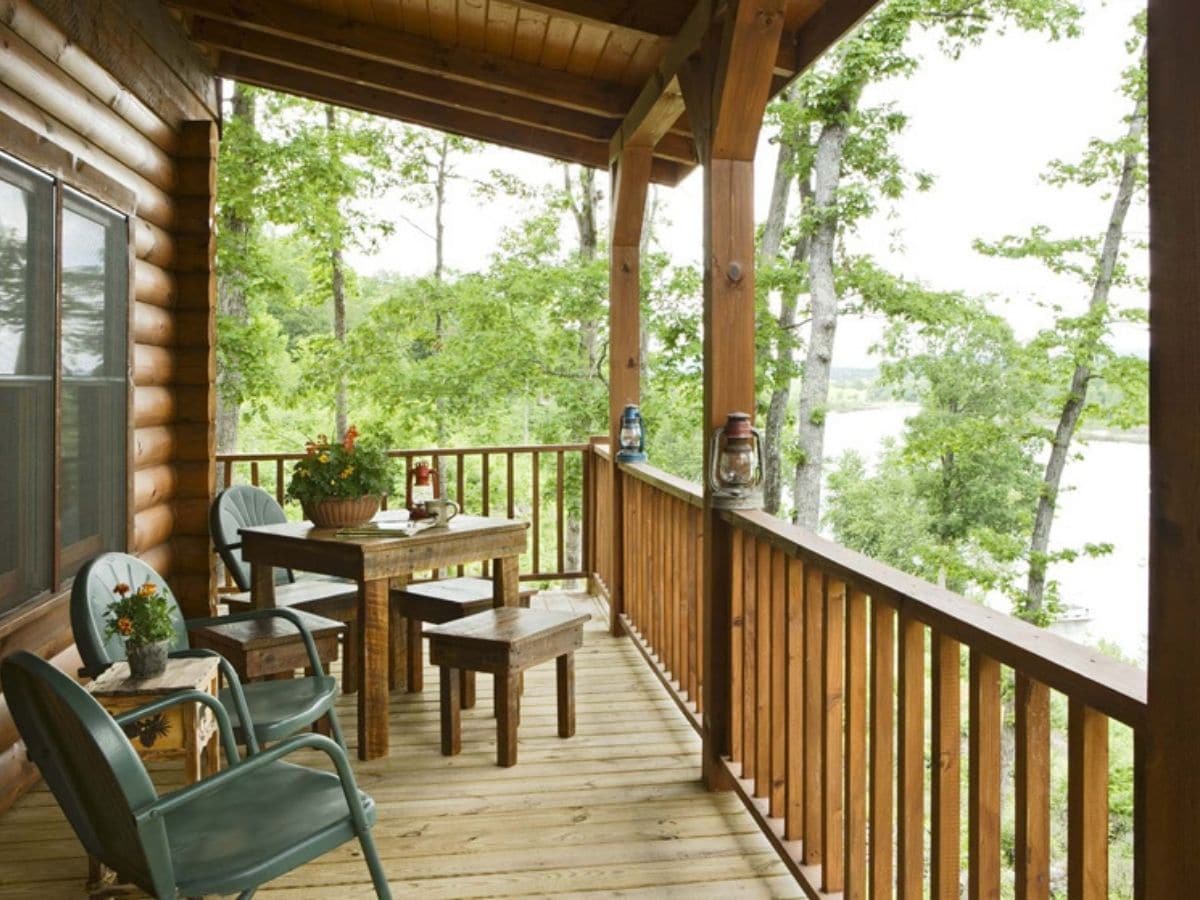 front porch with green chair and small wooden table at end