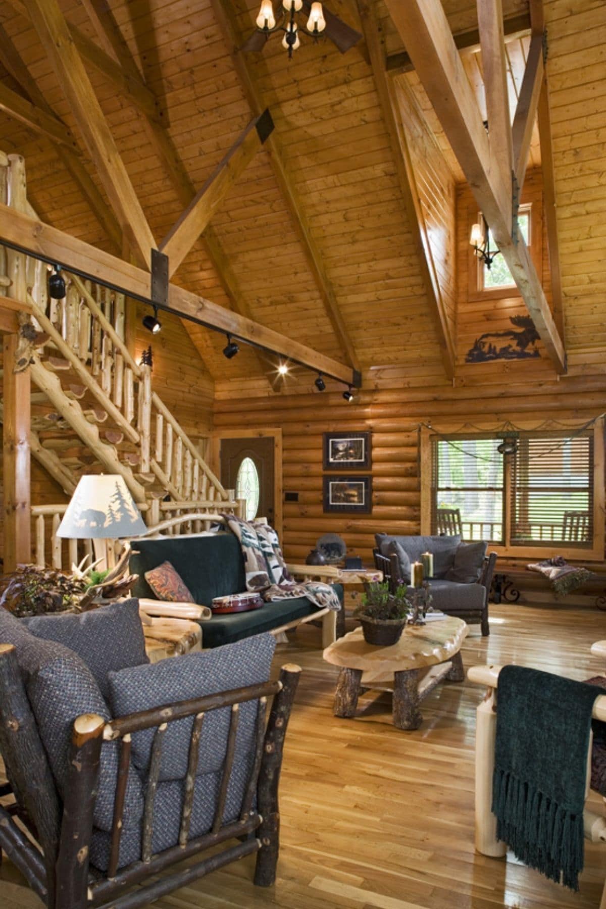 living room with blue cushions on wood chairs with wood staircase in background