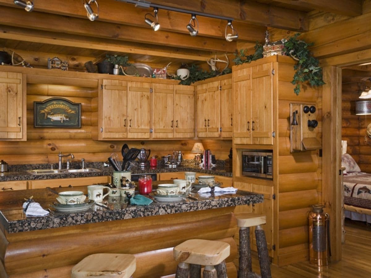 kitchen with wood cabinets and marble countertop with wood stools in foreground