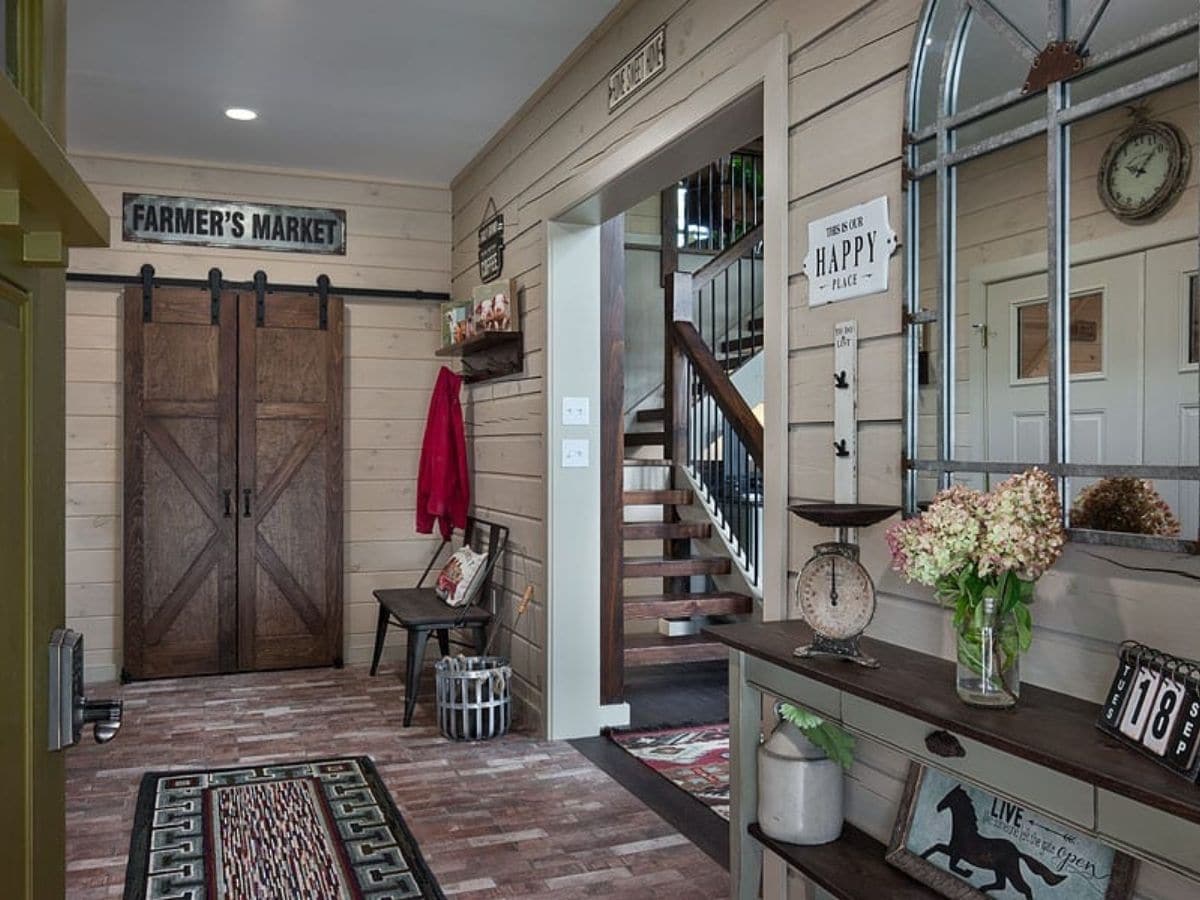 entry with barn door against far wall and open archway by stairs on right