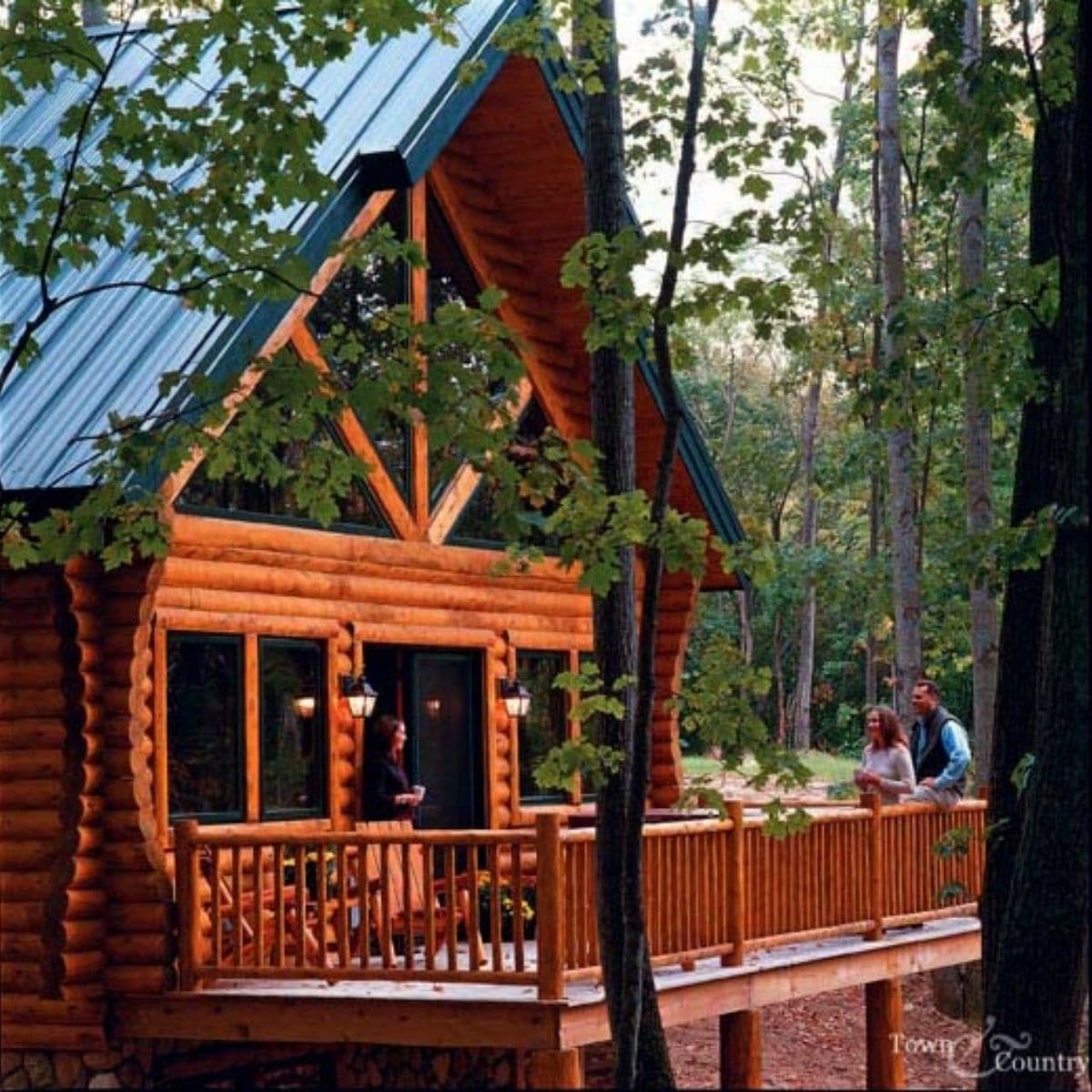 deck on back of log cabin with trees on either side