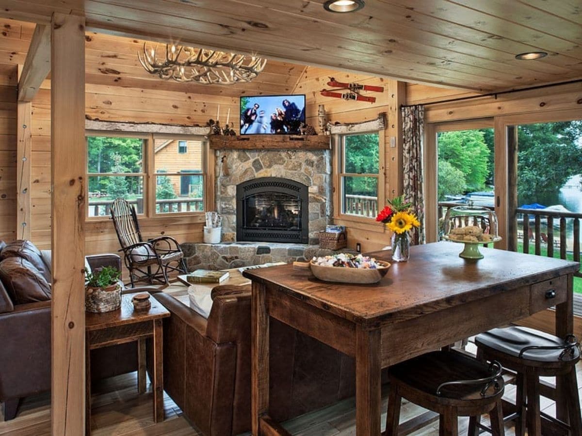 view over backs of sofa toward living room with stone fireplace in corner