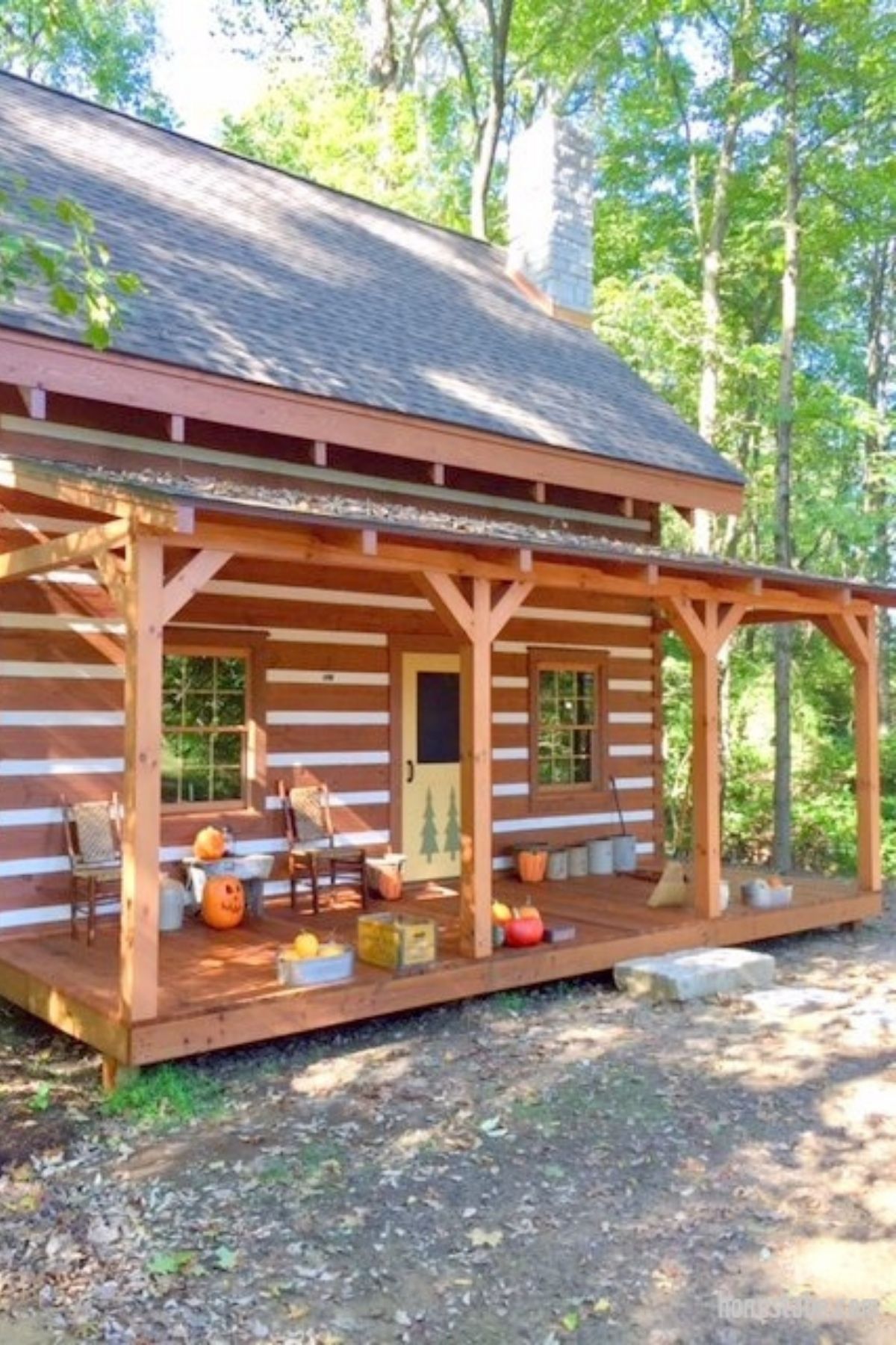 log cabin front with porch and shingle roof