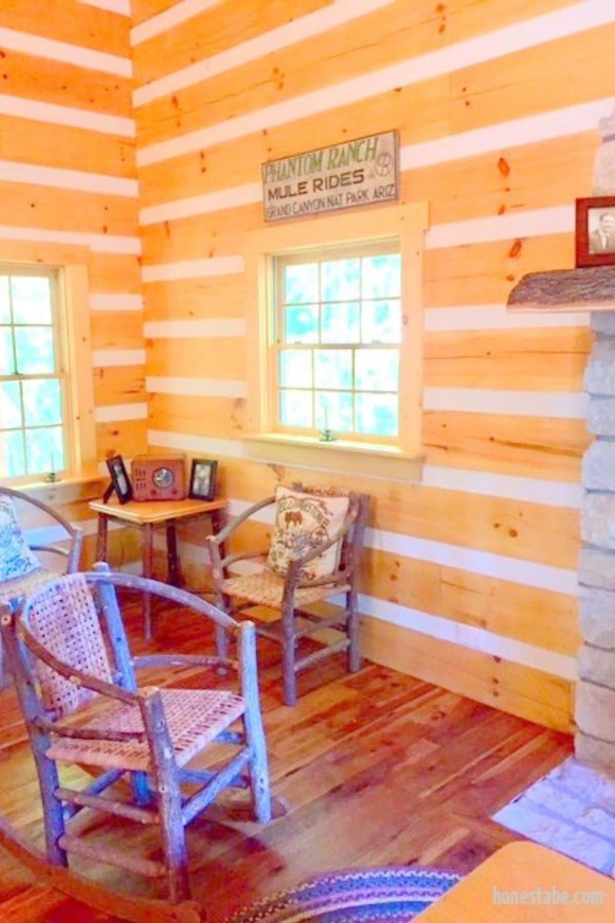rocky chair in front of small two person table in corner of log cabin