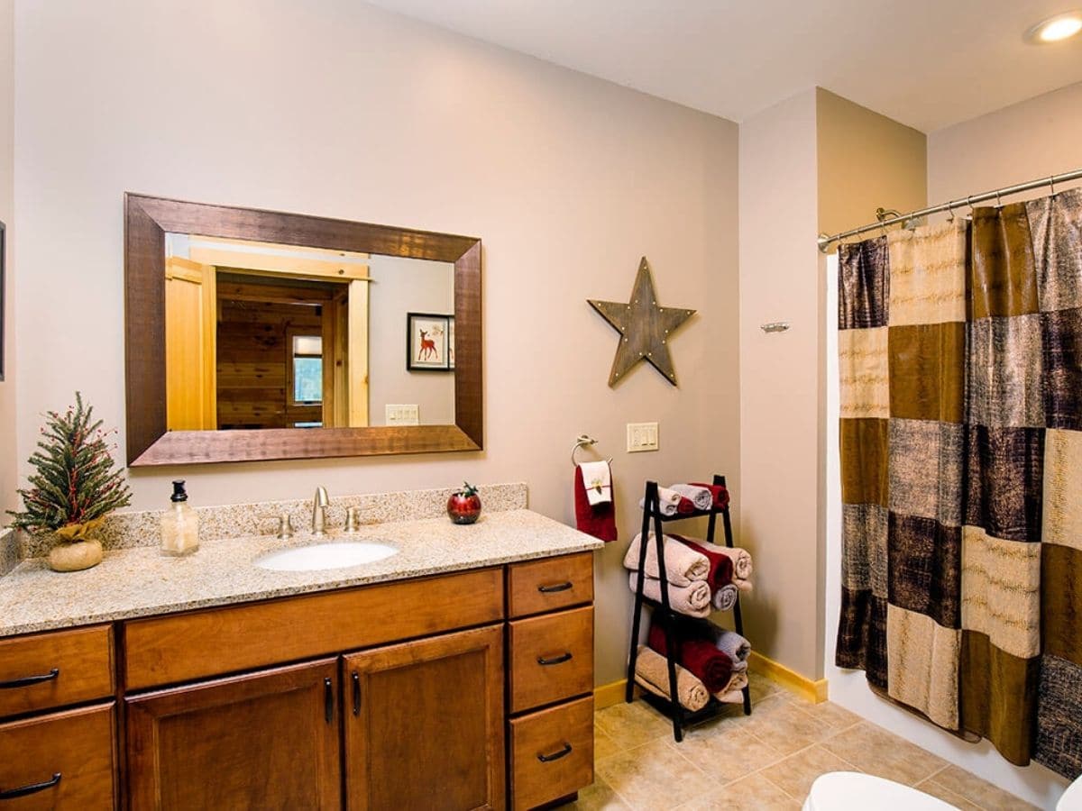 bathroom with white walls dark wood cabinets and white vanity and sink with rectangle mirror above vanity