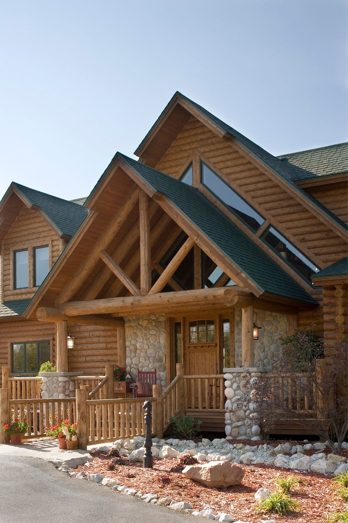 front door to log cabin with green roof and rock columns