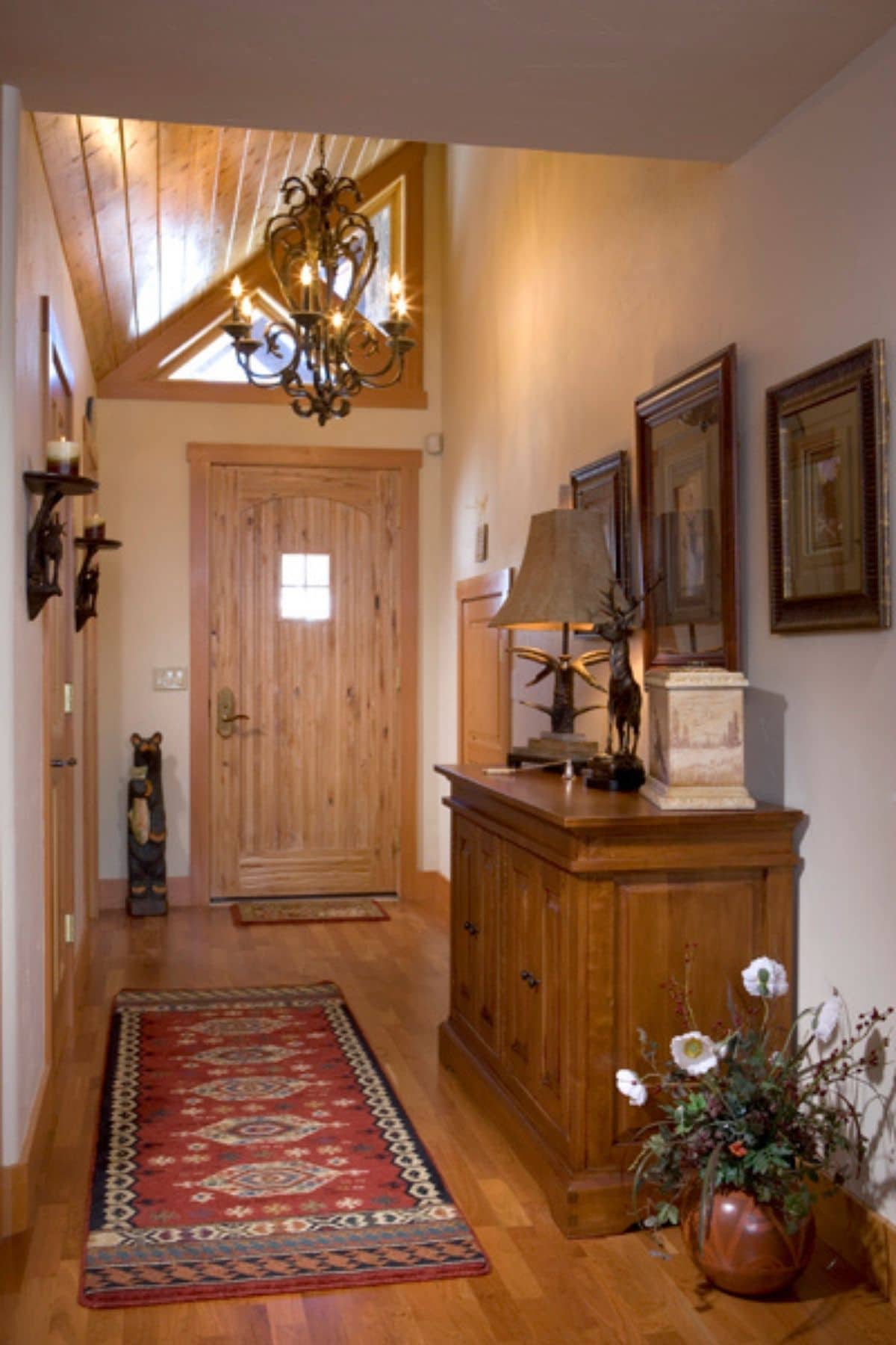 entryway to log cabin with small buffet against wall with photos
