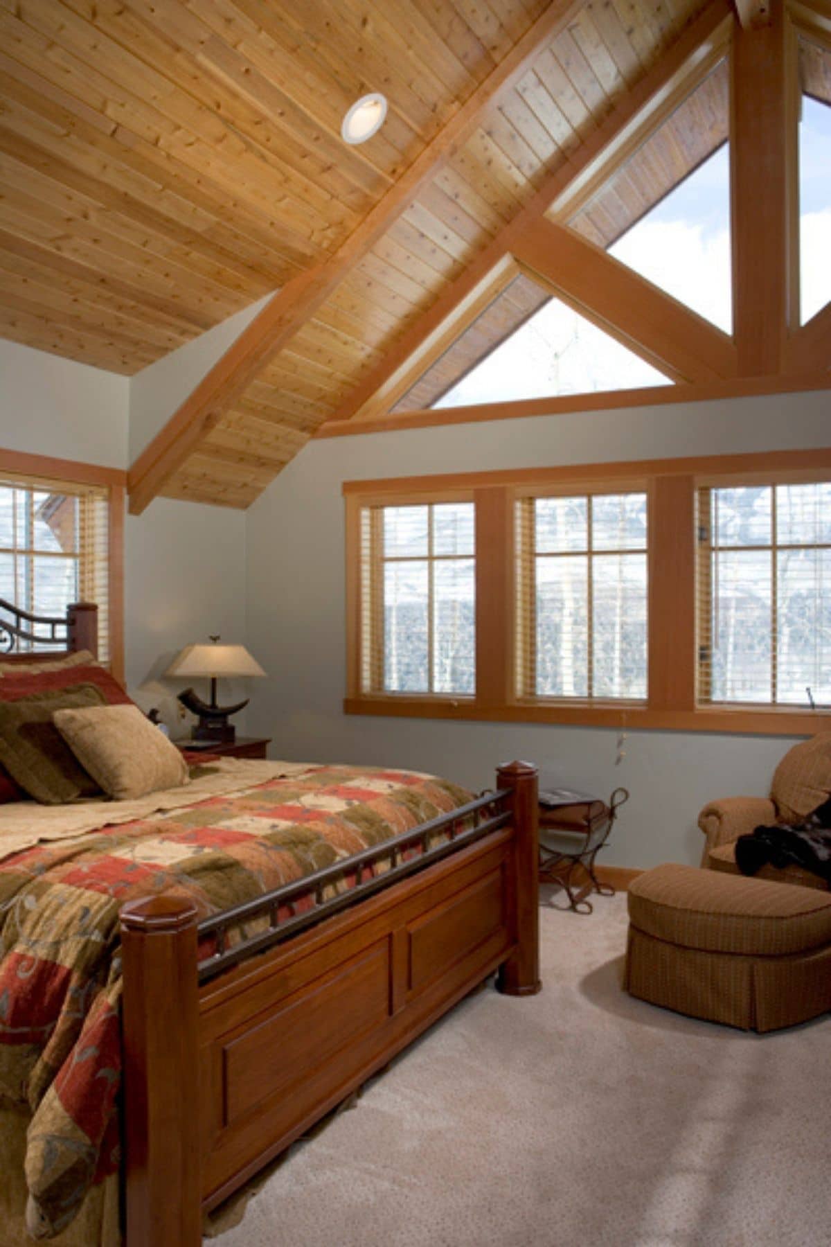 wooden bedframe with white walls and light wood ceiling in bedroom