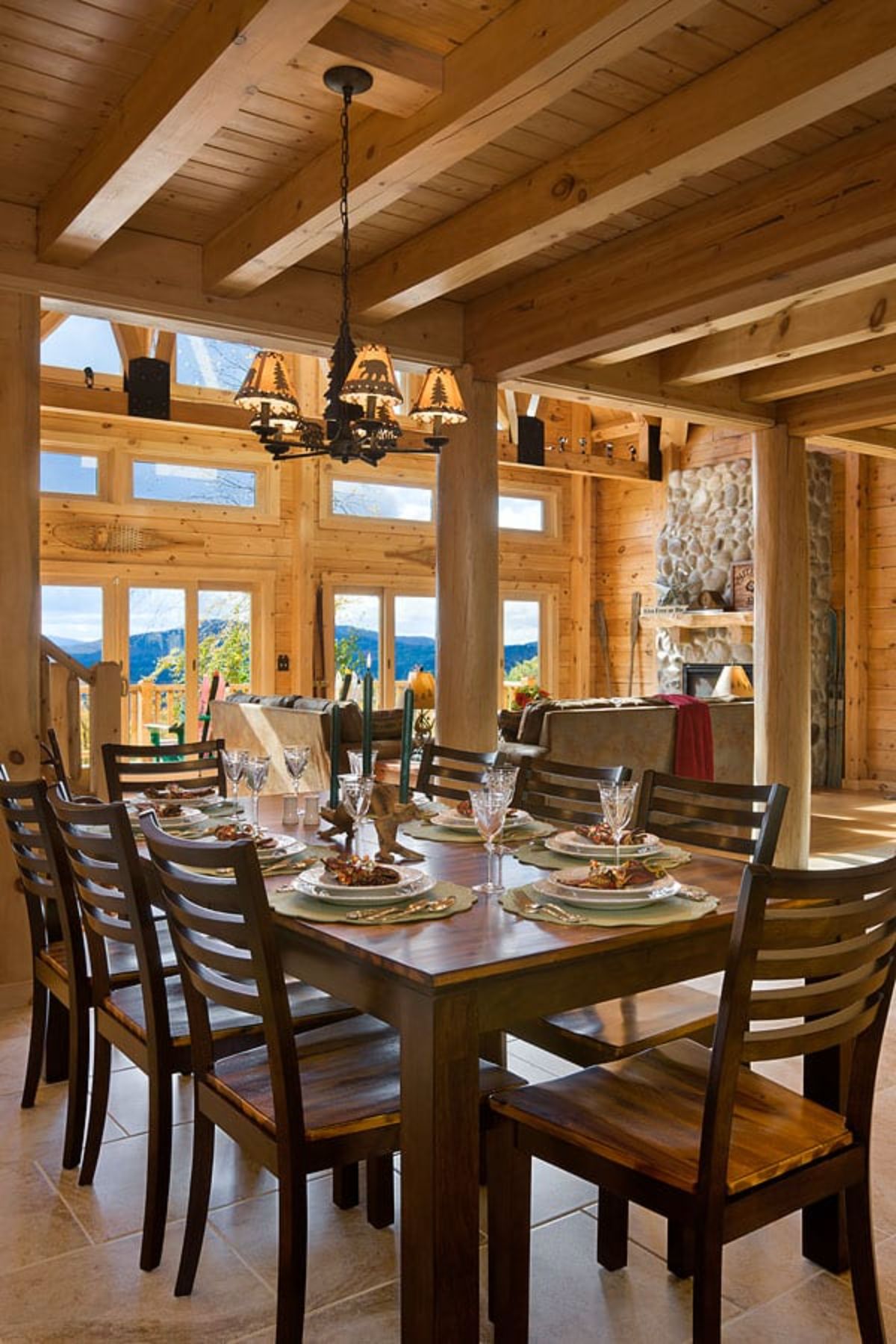 table with 8 chairs below lighting with picture windows in background