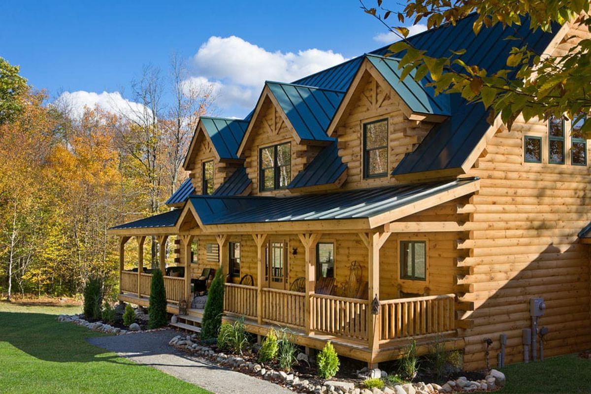 light blonde log cabin with porch and dormer windows on front