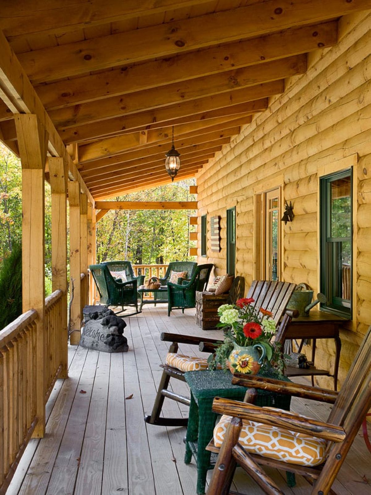 light blonde log cabin with green rocking chairs
