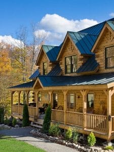 light blonde log cabin with porch and dormer windows on front