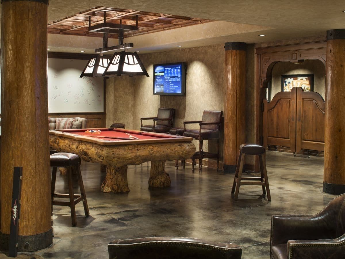 pool table underneath three light fixture with stools on edges