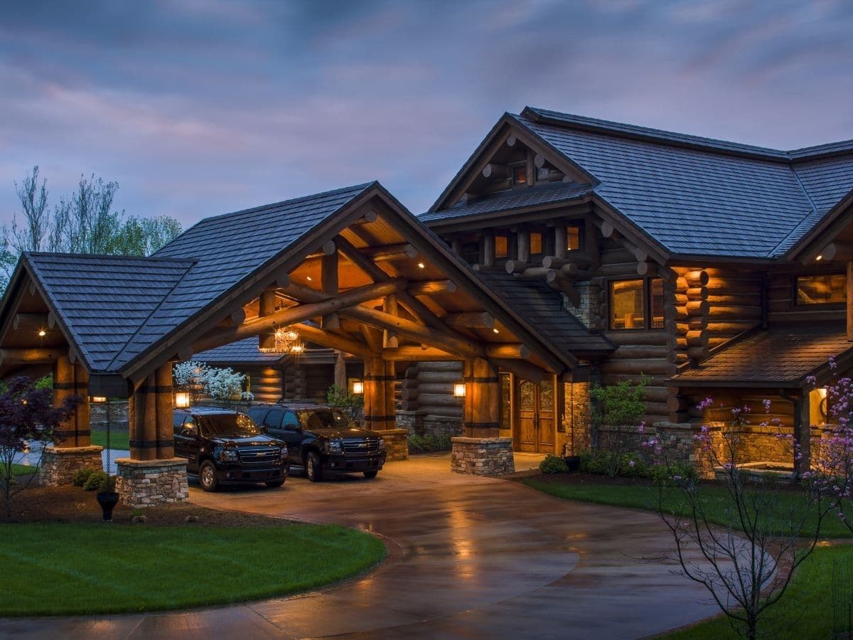 log cabin with carport holding two SUV's