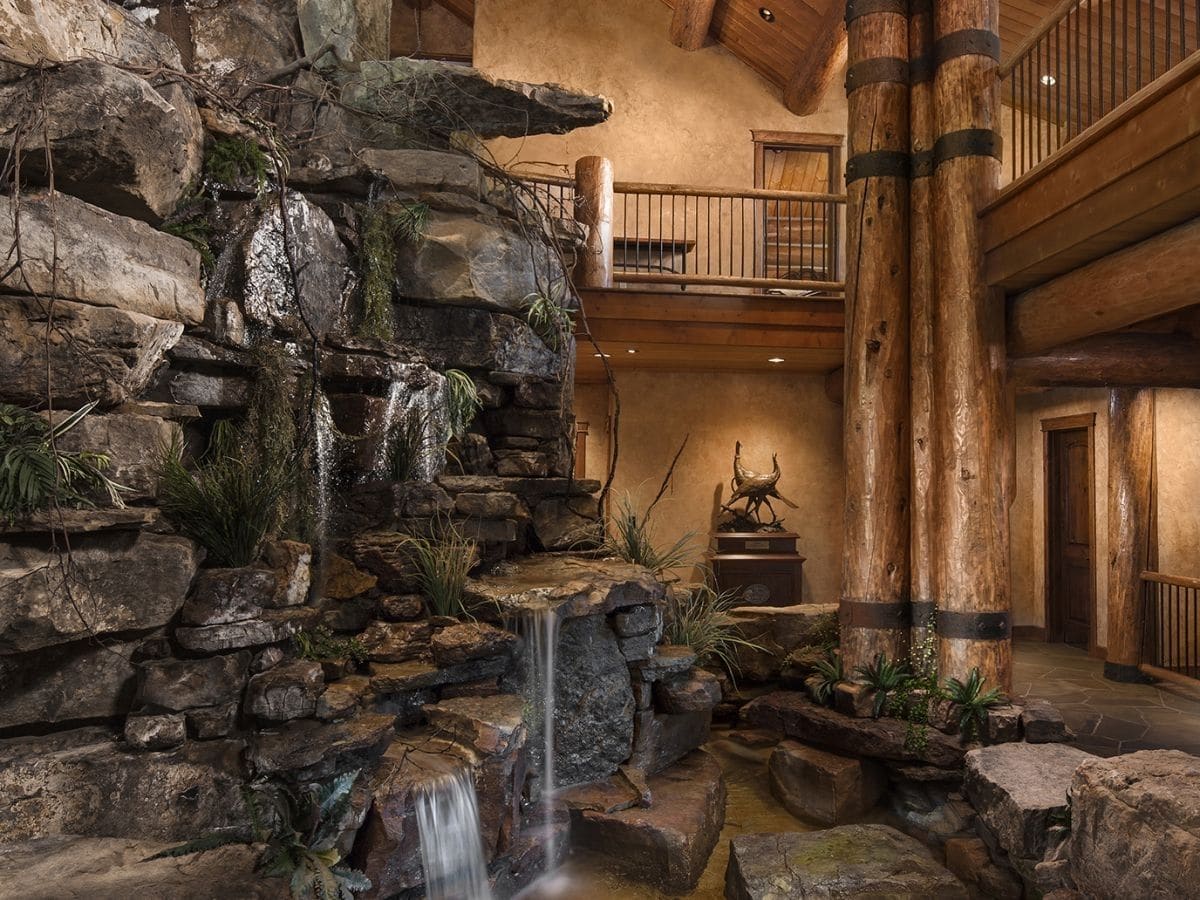 waterfall in middle of log cabin living area