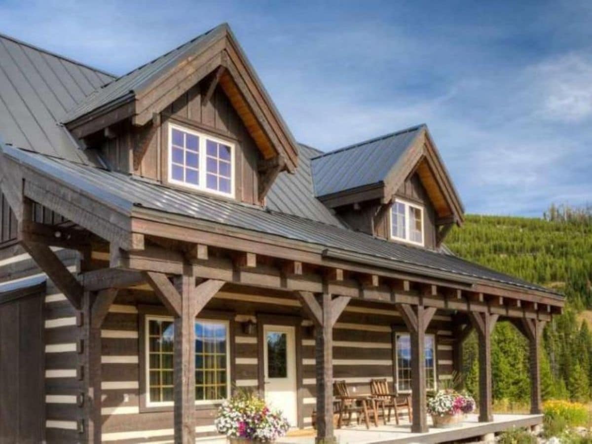 Dark wood log cabin front porch with white front door