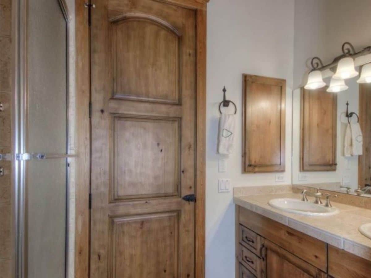 bathroom sink on right with wood doors against the wall