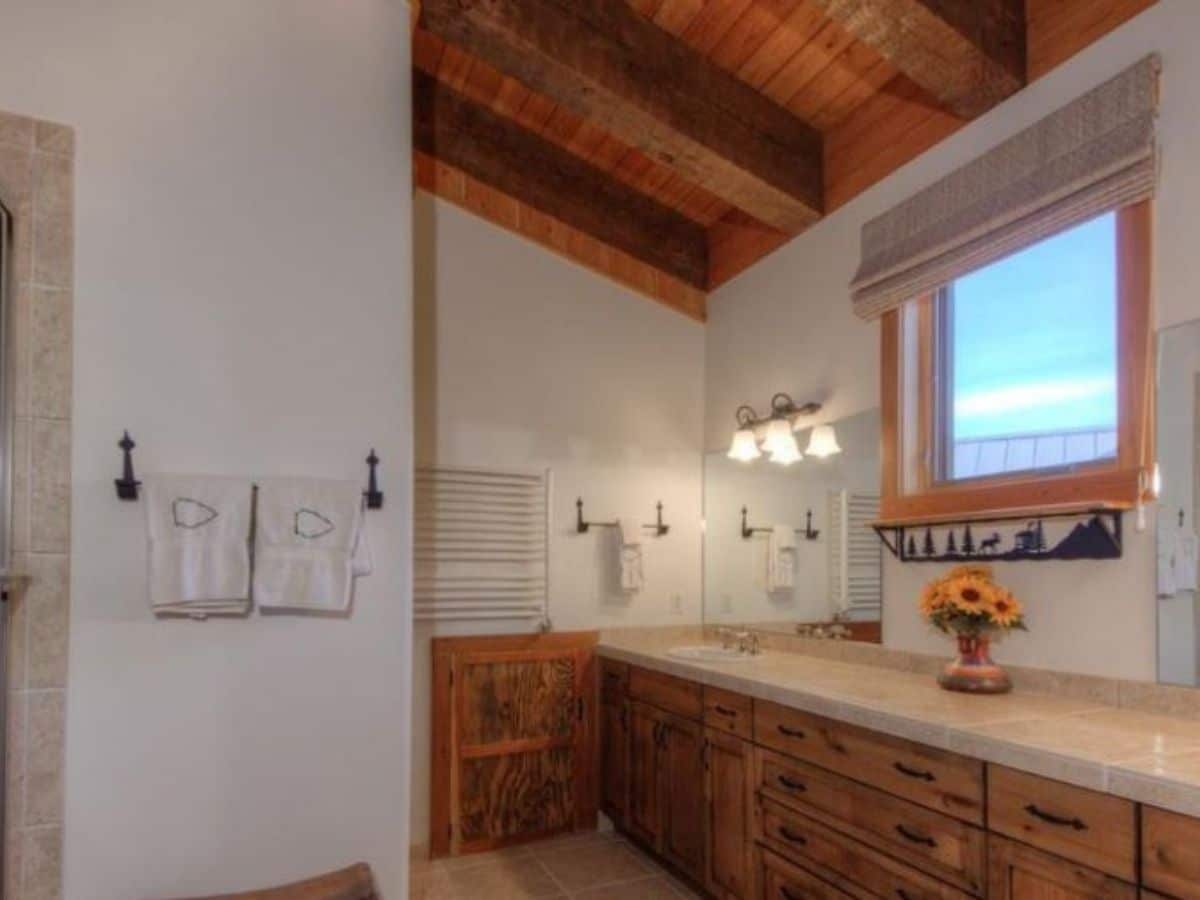 wood cabinets in bathroom underneath vanity with light wood walls
