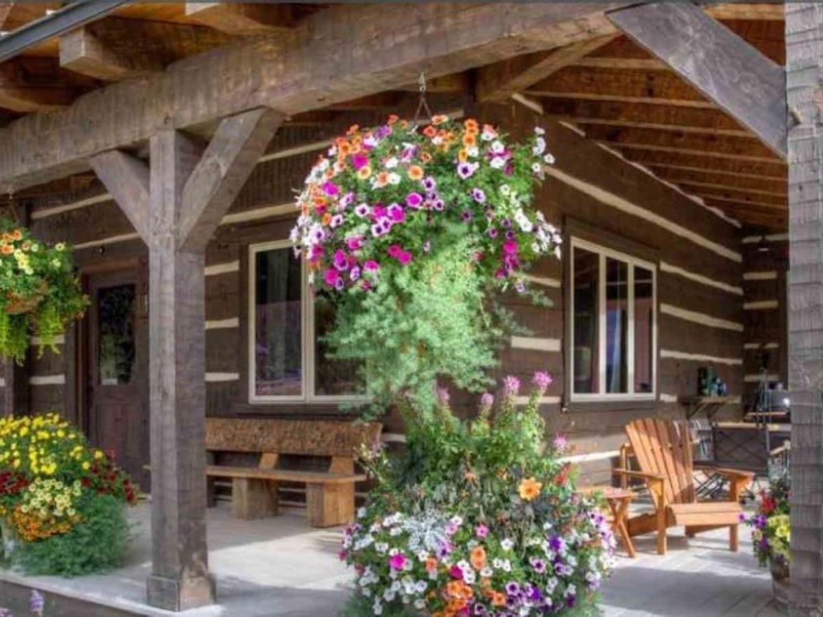 hanging flower basket on porch of log cabin