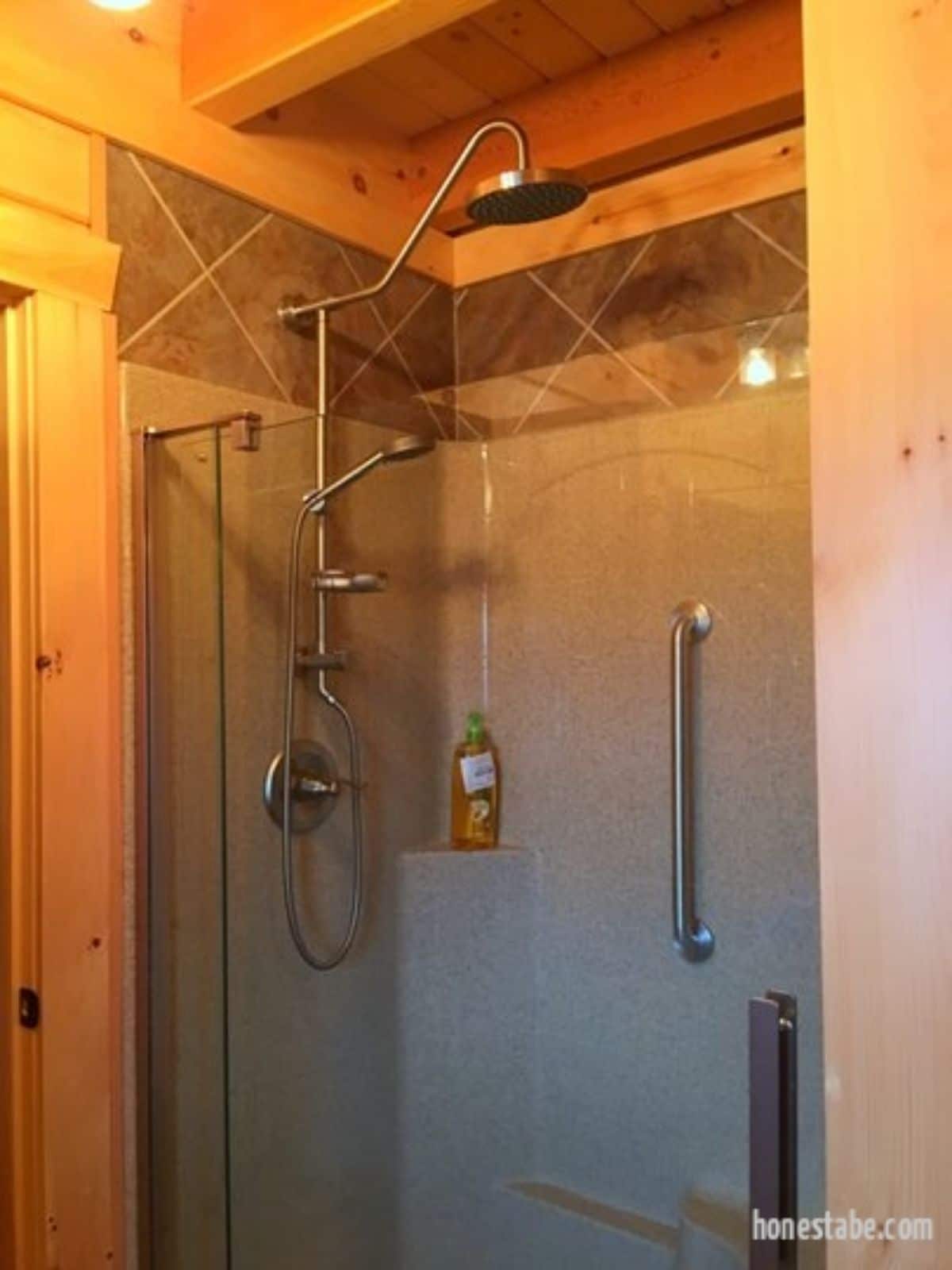 light gray tile shower stall with log surround