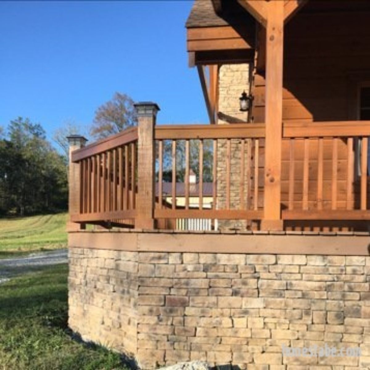 side of wrap around porch on log cabin with stone foundation