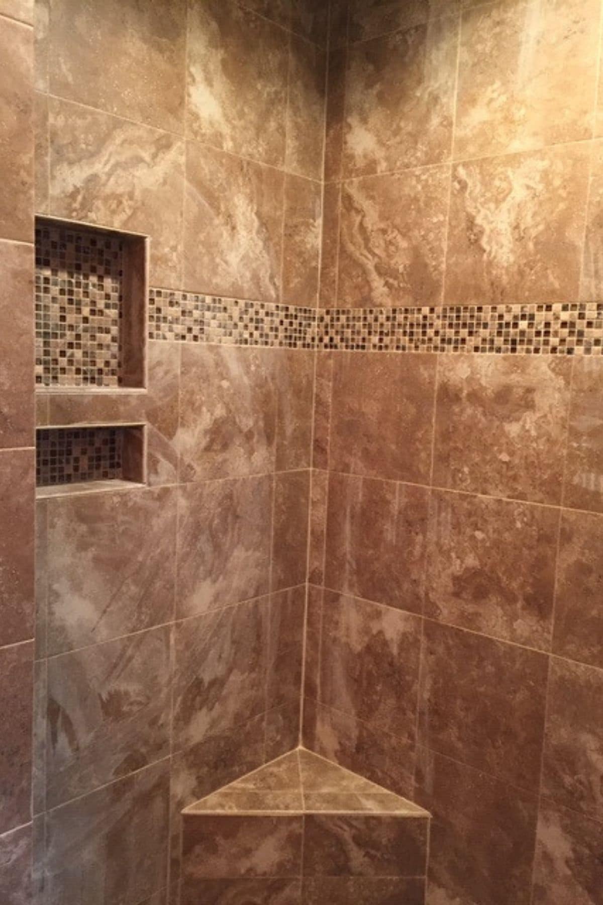 marbled tile shower with intricate stone around builti ns helves