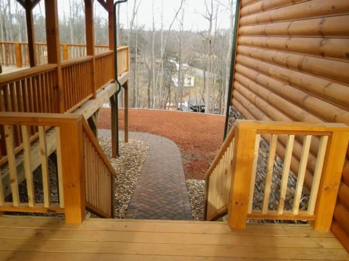 view down stairs on log cabin with stone walkway