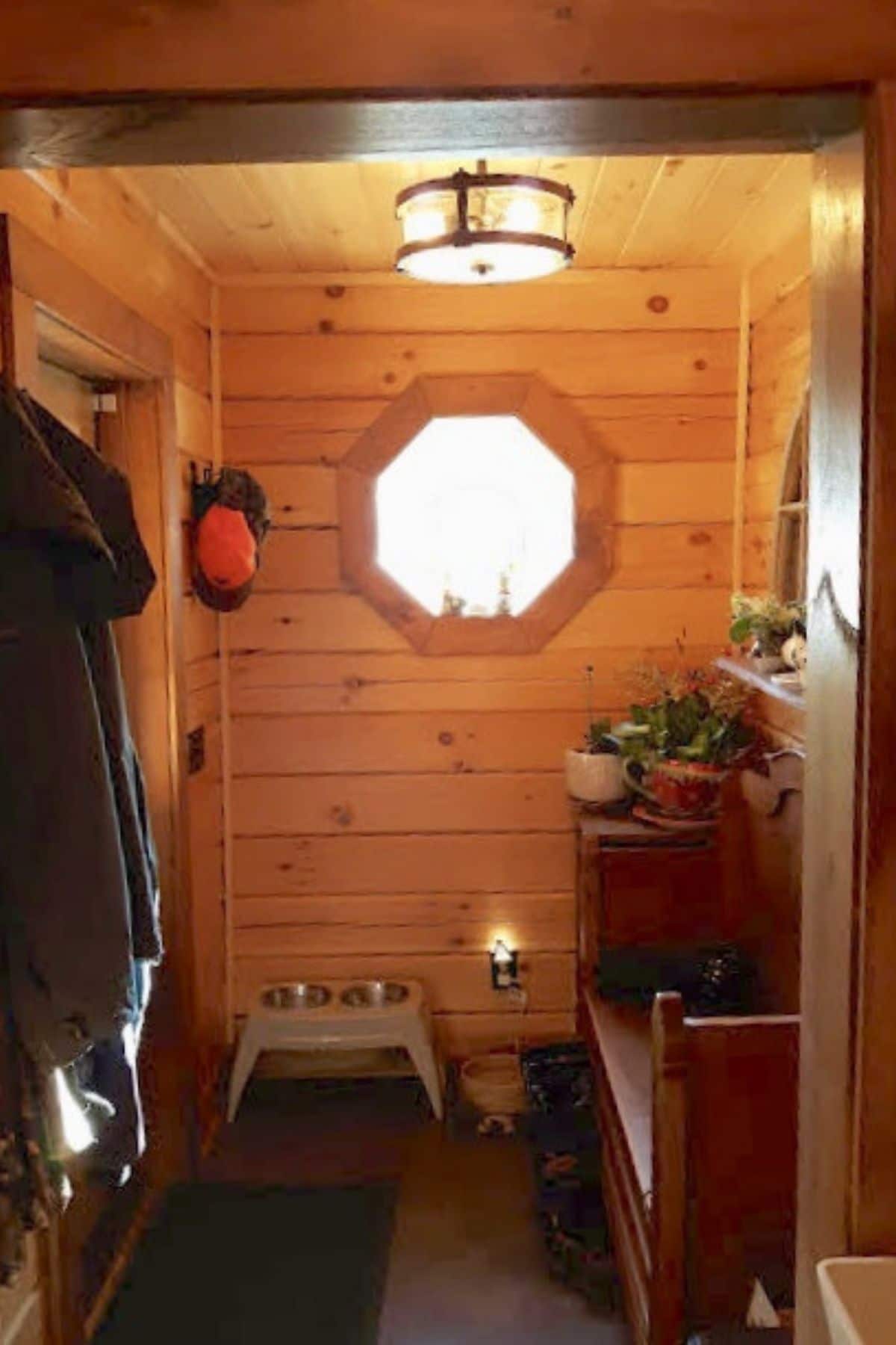porthole window on wall inside log cabin entrayway