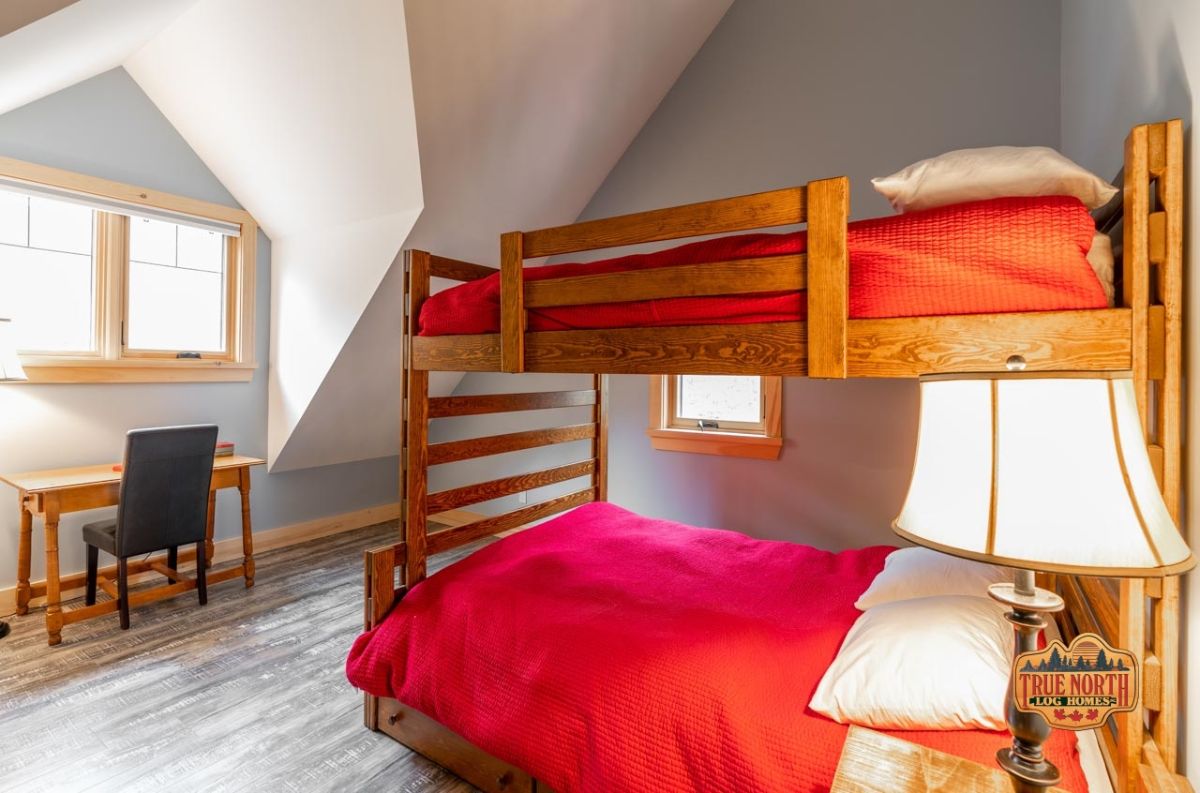 red bedding on wood bunkbeds under white ceiling