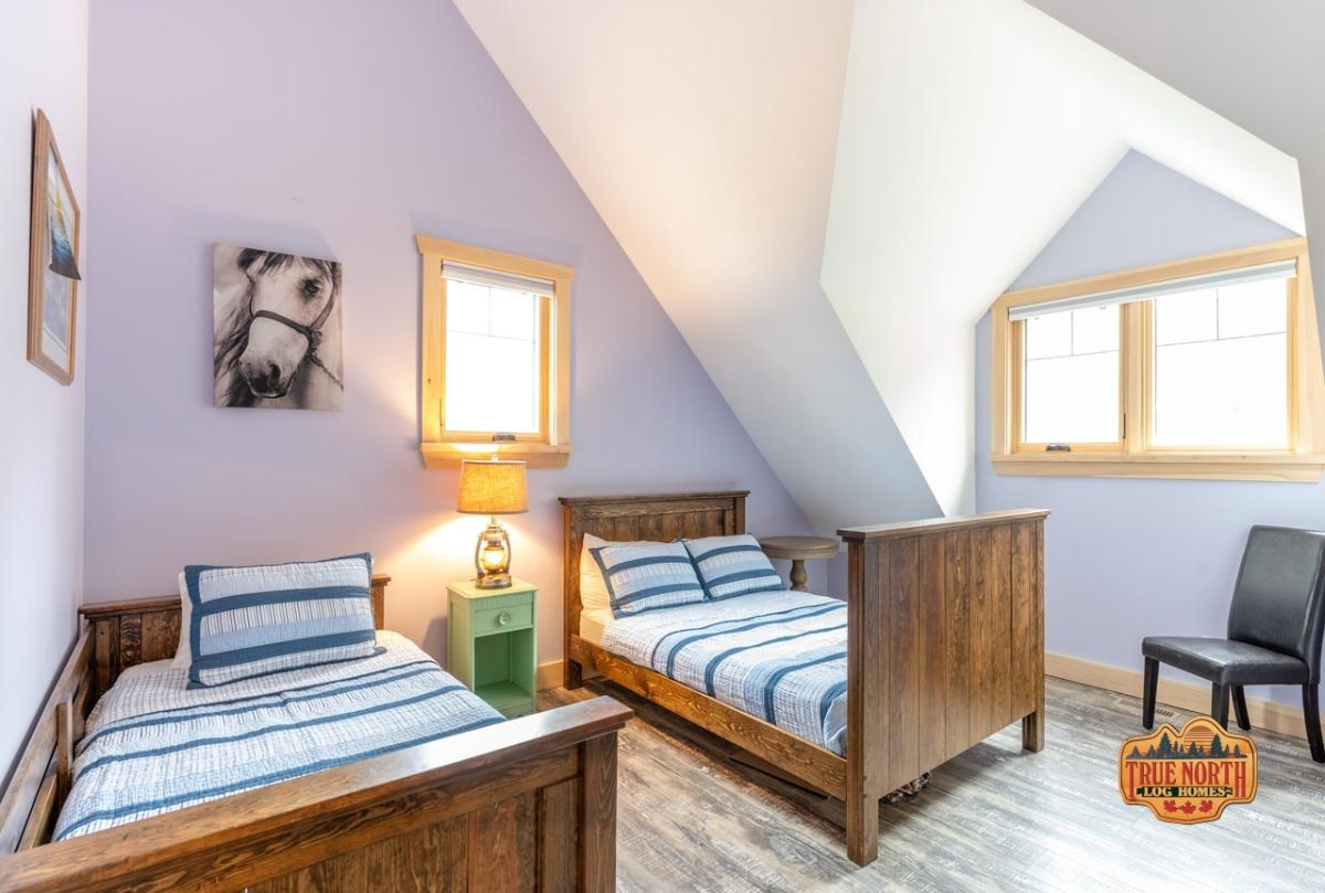 twin beds with wood frames and blue striped bedding against pale purple wall