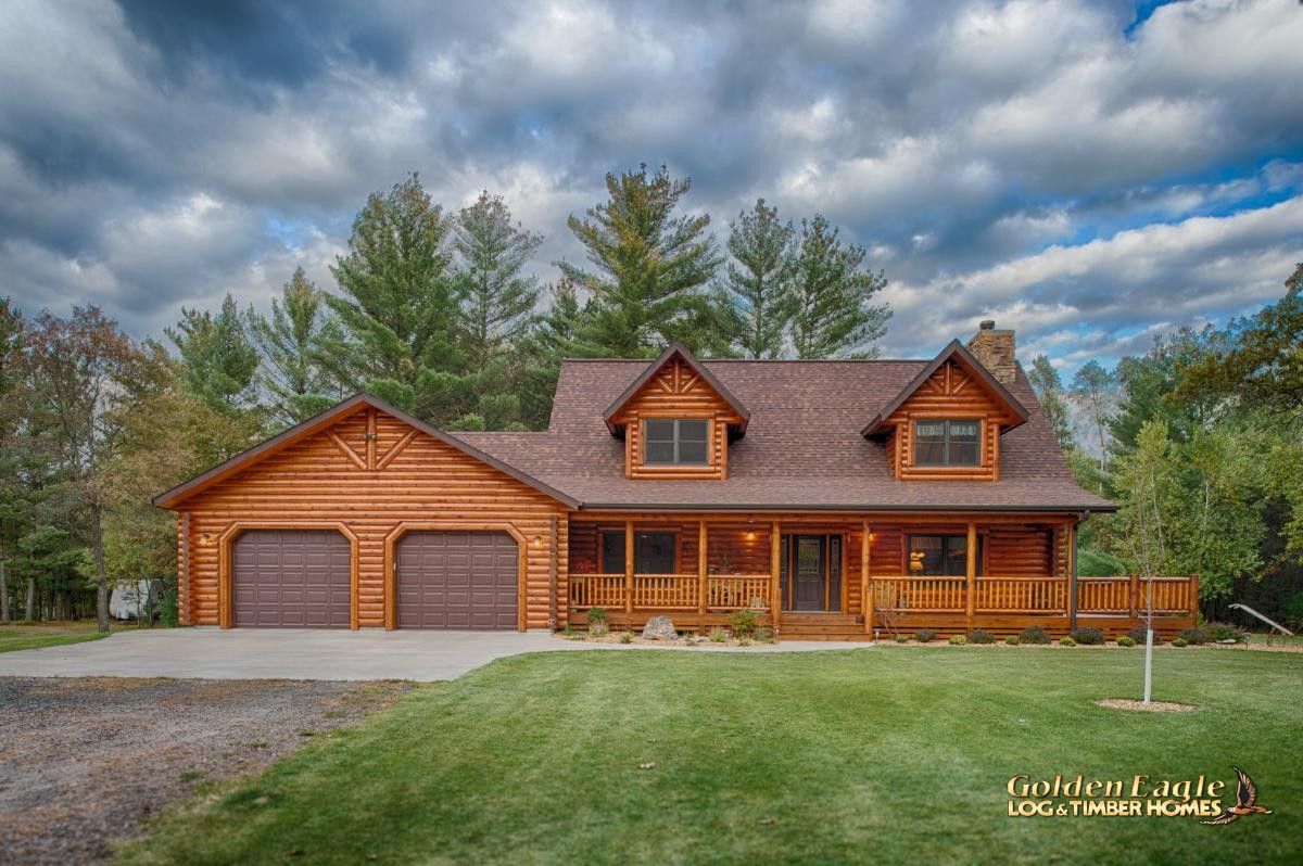 log cabin with two brown garage doors and dormer windows on front