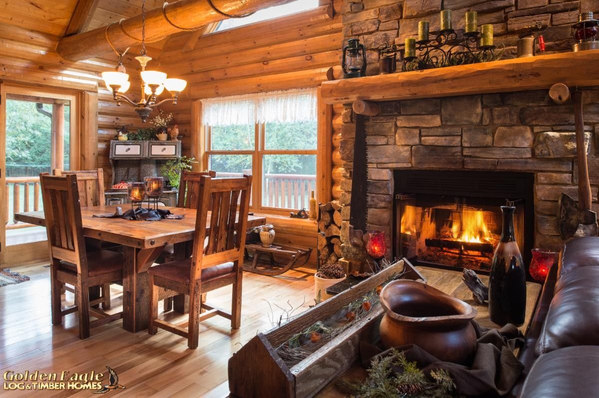 dining table on left with fireplace on right of log cabin