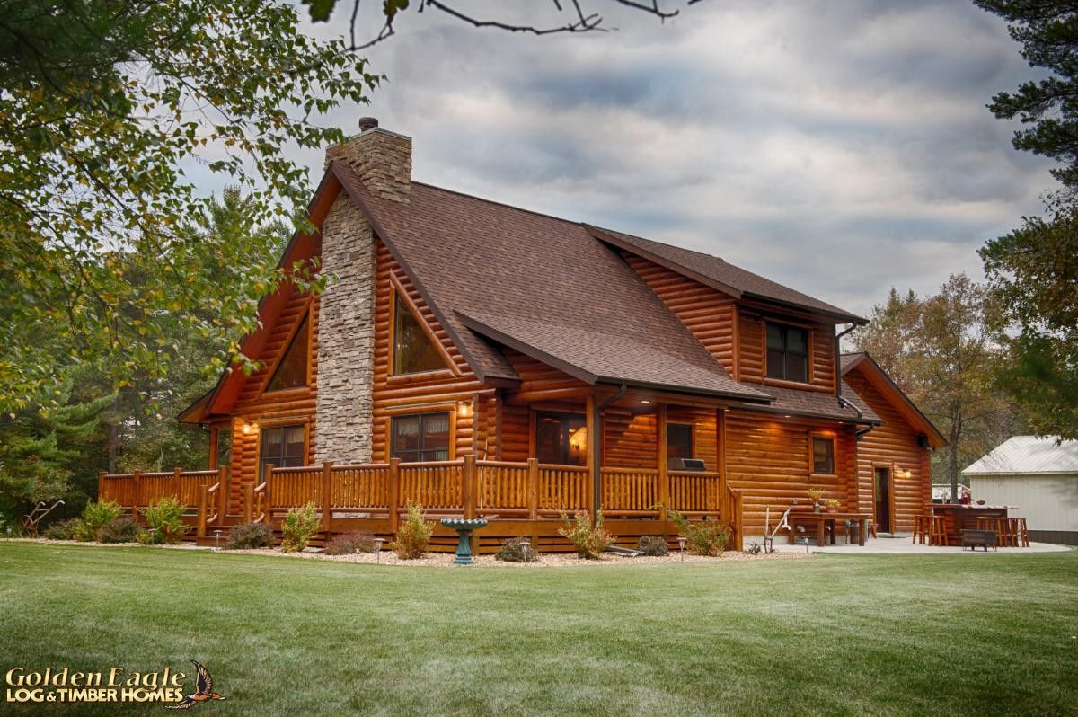 side of log cabin with stone chimney along side wall with wrap around porch